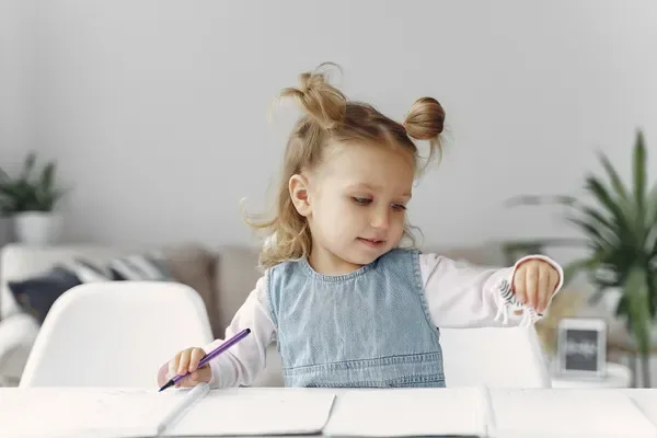 A primary-age learner holding a star during a creative activity