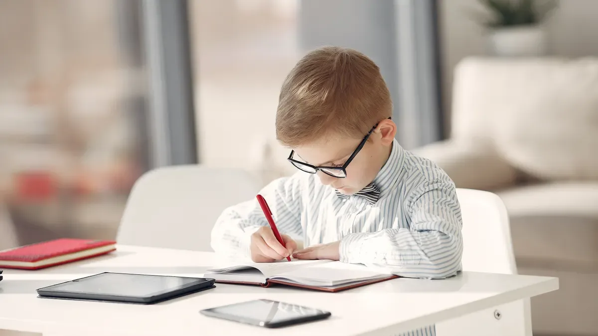 A child taking an online lesson at home with headphones